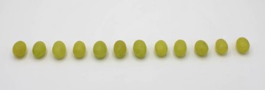 Beyaz arka planda izole edilmiş on iki üzümün yakın çekimi.