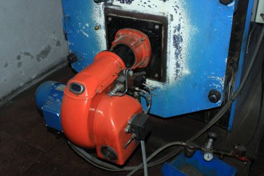 Old gas-oil burner in a boiler room 