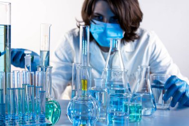 Genç bilim adamı bir laboratuarda pipetle örnek alıyor.