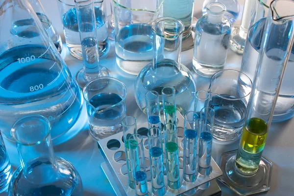 Beher, matara, mezun olmuş silindirler ve test tüpleri gibi laboratuvar malzemelerini kapatın.