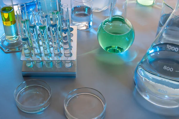 Beher, matara, mezun olmuş silindirler ve test tüpleri gibi laboratuvar malzemelerini kapatın.