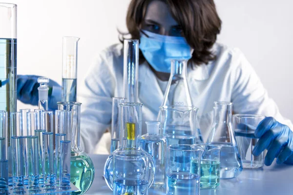 Genç bilim adamı bir laboratuarda pipetle örnek alıyor.