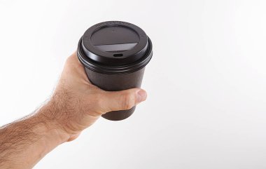 Genç adam beyaz arka planda kahve içiyor. Tek kullanımlık kahve fincanı beyaz arka planda.. 