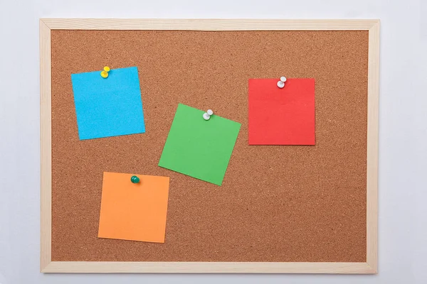 Colorful note papers on cork board (bulletin board). Post-it.