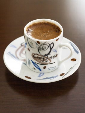 Ahşap bir masa arkasında bir fincan sıcak kahve. Türk kahvesi.