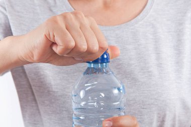 Kadın elinde plastik su şişesi tutuyor..