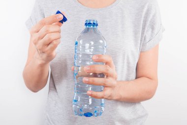 Kadın elinde plastik su şişesi tutuyor..