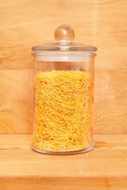 Ahşap arka planda cam kavanozda pişmemiş vermicelli..