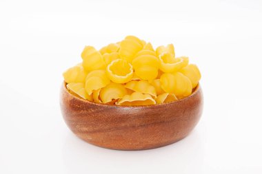 beyaz zemin üzerine ahşap kase pişmemiş makarna.
