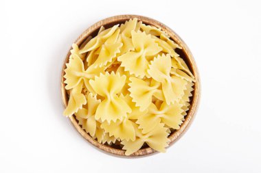 beyaz zemin üzerine ahşap kase pişmemiş makarna.