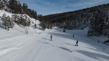 Uzun karlı ağaçlar, çalılar ve gün doğumu. Ormanda kar yağar, güzel kış manzaraları olur ve insanlar asansörde kalır. Doğa manzarası ve tatil konsepti.