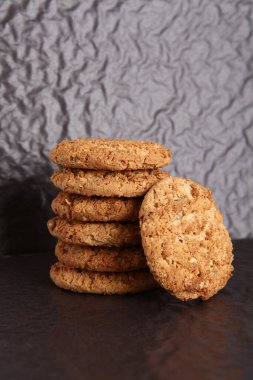  Siyah arka planda yulaf ezmesi, incir, fındık, fıstık ve susamlı kurabiye. Keyifli atıştırmalar.