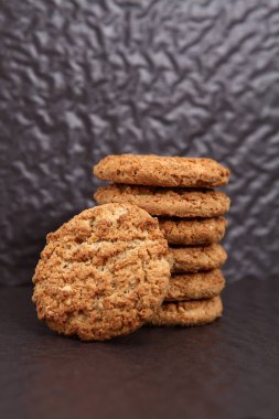  Siyah arka planda yulaf ezmesi, incir, fındık, fıstık ve susamlı kurabiye. Keyifli atıştırmalar.