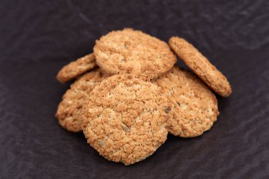  Siyah arka planda yulaf ezmesi, incir, fındık, fıstık ve susamlı kurabiye. Keyifli atıştırmalar.