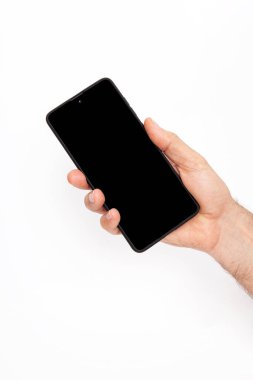 El ele tutuşan cep telefonu ve şablon reklamcılığı ve markalaştırma teknolojisi için boş ekran. İnce çerçeveli ve boş beyaz ekran izole edilmiş gerçekçi akıllı telefon modeli. Herhangi bir kullanıcı arayüzü testi veya sunumu için kullanılabilir.