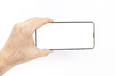 El ele tutuşan cep telefonu ve şablon reklamcılığı ve markalaştırma teknolojisi için boş ekran. İnce çerçeveli ve boş beyaz ekran izole edilmiş gerçekçi akıllı telefon modeli. Herhangi bir kullanıcı arayüzü testi veya sunumu için kullanılabilir.