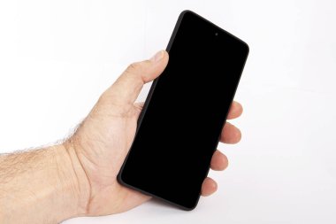 El ele tutuşan cep telefonu ve şablon reklamcılığı ve markalaştırma teknolojisi için boş ekran. İnce çerçeveli ve boş beyaz ekran izole edilmiş gerçekçi akıllı telefon modeli. Herhangi bir kullanıcı arayüzü testi veya sunumu için kullanılabilir.