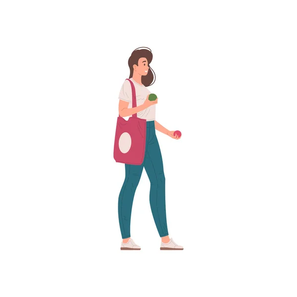 Sonriente joven hembra casual sosteniendo dos manzanas frescas de temporada va con el vector bolsa de compras plana — Vector de stock