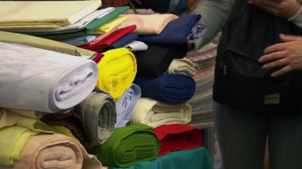 Muitos rolos de roupas coloridas e clientes ambulantes. — Vídeo de Stock