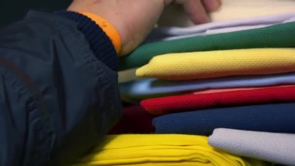 Close-up mannelijke hand kiezen kleding in de markt. — Stockvideo