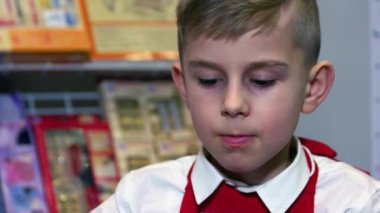 Aşağı bakan beyaz bir çocuğun yakın plan portresi..