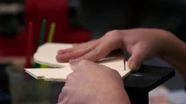 Yakın plan erkek, tahta çarşafı ortadan kesiyor..