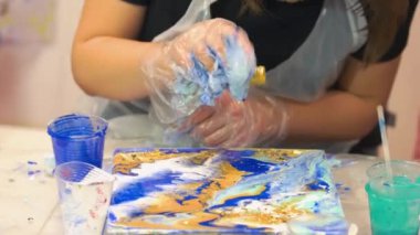 Tabloya sarı boya ekleyen bir kız..