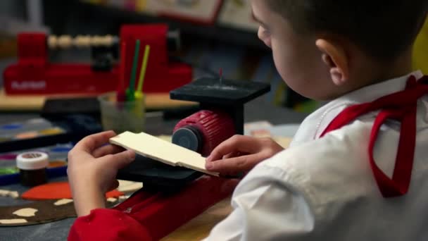 Jongen maken van houten figuur vorm met behulp van machine. — Stockvideo