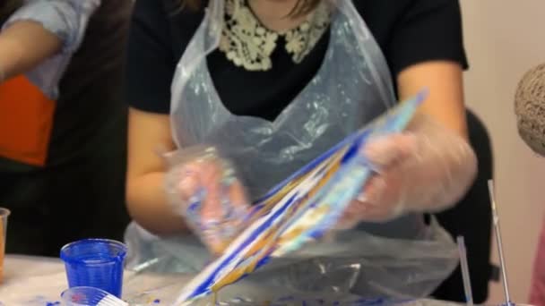 Meisje kunstenaar verwijderen verf druppels van haar schilderij. — Stockvideo
