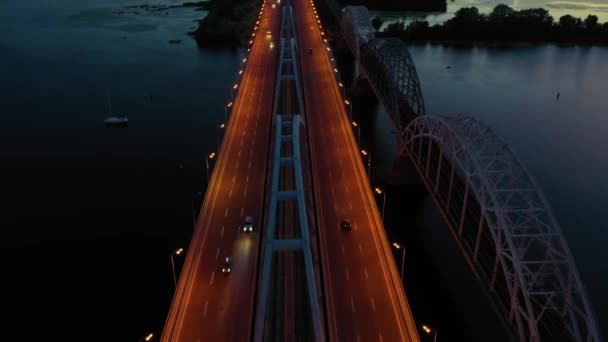 Blick von oben auf beleuchtete Straßenbrücke über den Fluss. — Stockvideo