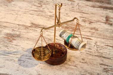 Masanın üzerinde dolar ve bitcoin ile pullar.