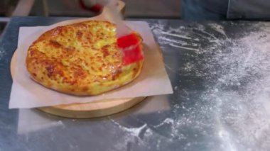 Yakın plan peynirli pizzayı fırçayla sürüyorum..