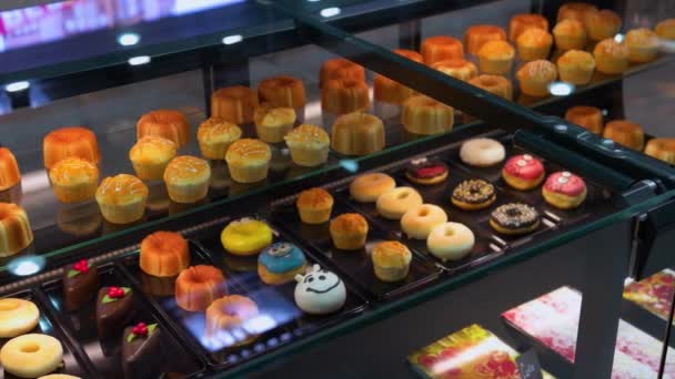 Krémové koblihy a dortíky v pekárně. — Stock video