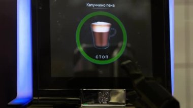 Dijital ekran ve robotik kollu kahve makinesi.