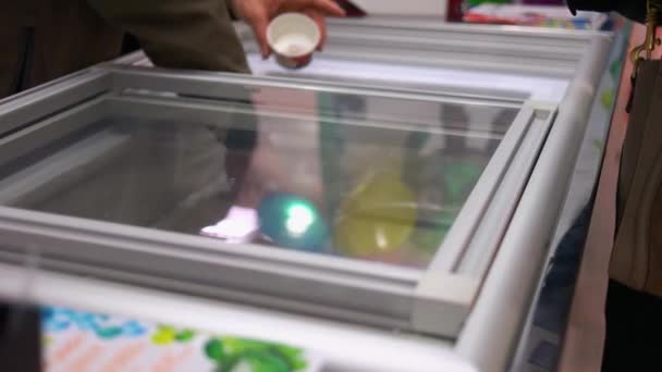 Рука бере солодкі кульки з холодильника . — стокове відео
