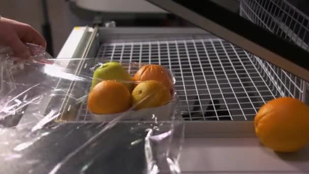 Close-up vrouwelijke handen verzegelen vruchten in luchtdichte plastic zak. — Stockvideo