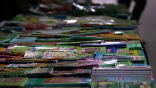 Les vendeurs trient les mains à travers une pile de magazines. — Video