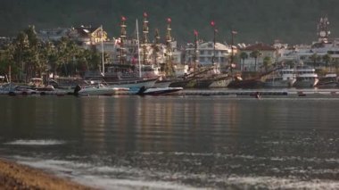 Deniz manzarası, tekneli marina, oteller ve dağlar..