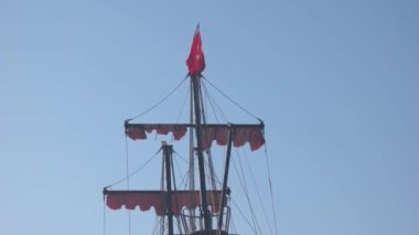 Açık mavi gökyüzünde Türk bayrağı olan yatın direkleri.