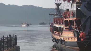 Arkasında yelkenliler ve dağlar olan deniz..