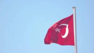 Mavi gökyüzü arka plan üzerinde Türkiye'nin bayrak sallayarak.
