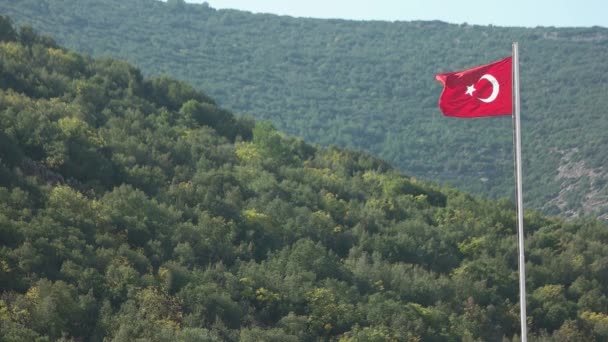 Turecká vlajka na zelených zalesněných kopcích pozadí. — Stock video