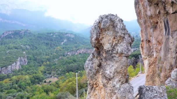 Rotsachtige klif op de achtergrond van de groene bergvallei. Scenic rotsachtige vorming over landweg. — Stockvideo