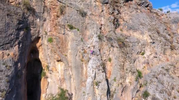 Bergsklättrare klättrar på klippan. Flygfoto från drönare. — Stockvideo
