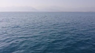 Güzel deniz manzarası ve ufukta dağ manzarası. Resimli deniz arkaplanı.