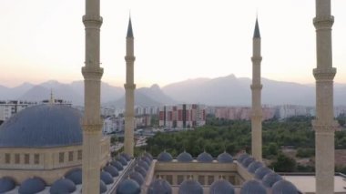 Türkiye 'nin Antalya bölgesindeki Manavgat Camii. Arka planda şehir binaları ve dağlar.