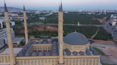 Güzel mavi kubbeleri ve minareleri olan bir cami. Arka planda şehir manzarası.