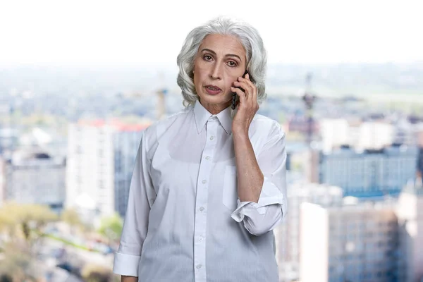 Портрет элегантной пожилой женщины, разговаривающей по мобильному телефону. — стоковое фото