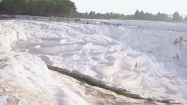 Natural travertine pools and terraces. Tourists at Pamukkale park.