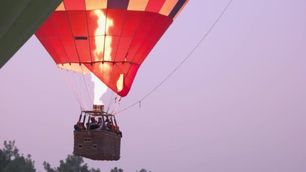 Gente en la canasta de globo de aire caliente ascendente con fuego. Gran atracción turística. — Vídeos de Stock